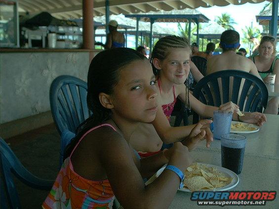 Children and adults seated at a table with food and drinks