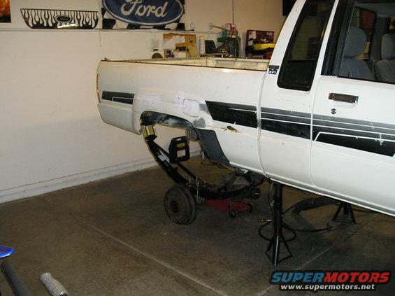 White 1986 Toyota Hilux side view with rear suspension exposed