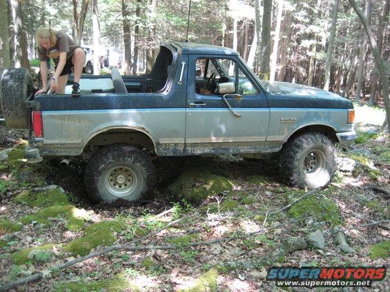 1991 Ford Bronco off-roading in woods, side view