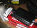 1992 Ford Mustang - A black diamond plate exhaust muffler sits on top of several Flowmaster boxes, with other vehicle parts visible in the background.