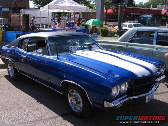 Blue and white 1970 muscle car with racing stripes, front 3/4 view
