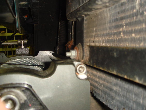 Close-up of radiator core and support bracket bolt behind front grille area