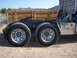 1981 Kenworth W900A - The rear wheels and chassis of a truck are visible from the side, alongside a metal toolbox.