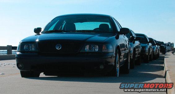 Black Mercury Marauder parked in a line of cars, front view