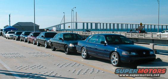 Blue 2003 Ford Crown Victoria police interceptor parked on a bridge, front 3/4 view