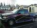 1998 Ford F-150 - This Ford F-150 pickup truck has custom graphics on its side and is parked in a residential area.