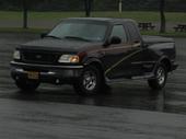 Dark brown Ford F-150 pickup truck with a short bed, seen from the front-right
