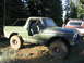 1979 Ford Bronco - This 1979 Ford Bronco, with its doors off, is seen parked in a wooded area next to another vehicle.