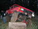 1979 Ford Bronco - A heavily modified red Ford truck navigates an obstacle during an outdoor event.
