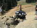 1979 Ford Bronco - A black SUV navigates a challenging rocky trail, with other vehicles visible in the background.