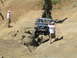 1979 Ford Bronco - A Ford Bronco navigates a rocky trail, with a spectator observing the challenging terrain.
