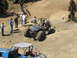 1979 Ford Bronco - Two off-road vehicles are seen on a dusty, rocky terrain with several spectators.