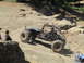 1979 Ford Bronco - An off-road buggy navigates a steep, rocky trail with spectators watching.