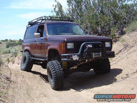 1986 Ford Bronco II with roof rack and winch on a dirt trail