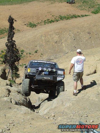 Black 1979 Ford Bronco off-roading, with "BIG BRONCOS 4X4 CLUB" sticker on windshield