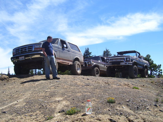 1989 Ford Bronco 3q-front view with two other SUVs behind it on a dirt hill