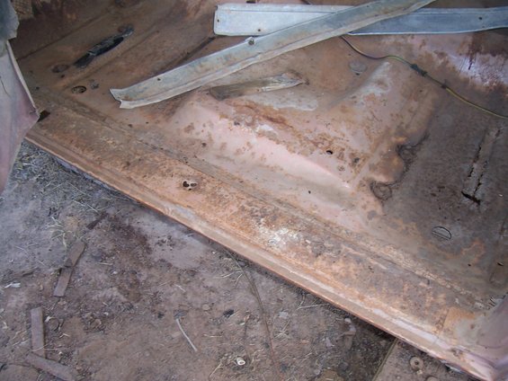 Interior floor pan of a 1955 Ford Customline showing rust and damage
