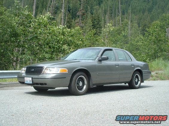 Gray 2000 Ford Crown Victoria, 3/4 front view, parked roadside