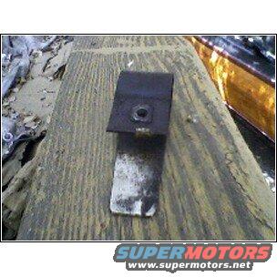 Black metal bracket with nut on wooden surface