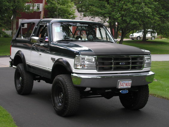 Dark green and white Ford Bronco with aftermarket wheels and tires. License plate reads 342 NOO
