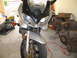2003 Suzuki Bandit S - Front view of a silver motorcycle, possibly a Suzuki Bandit S, with clear turn lenses and visible SUZUKI badging.