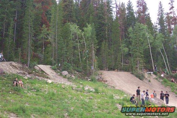 Mountain bike jump course with trees and spectators