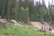1978 Ford Bronco - A mountain bike jump course is set up on a wooded hillside with spectators watching.