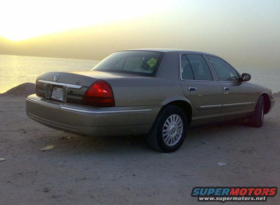 2007 Mercury Grand Marquis rear quarter view, parked on dirt near water at sunset