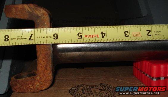 rusted metal part being measured with a yellow tape measure
