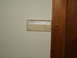 2004 Ford Crown Victoria - A beige thermostat is mounted on a light-colored wall next to a wooden door frame.