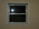 2004 Ford Crown Victoria - A closed window with blinds is shown, with a bright reflection visible in the glass.