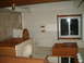 2004 Ford Crown Victoria - Interior scene of a bathroom with tiled walls, a toilet, a sink, and wooden cabinetry. A window is visible on the right wall.