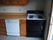 2004 Ford Crown Victoria - Kitchen scene showing a dishwasher and a stove next to wooden cabinets.