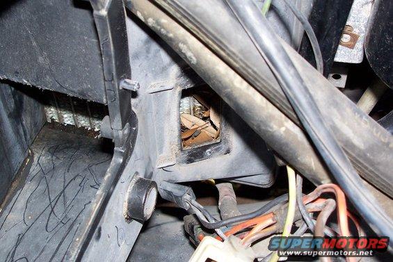 1984 Ford F-250 HVAC vent filled with leaves and debris, with visible wiring