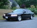 2002 Ford Crown Victoria - A black 2002 Ford Crown Victoria is parked on the side of a road with a house in the background.