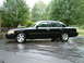 2002 Ford Crown Victoria - Side view of a black 2002 Ford Crown Victoria LX Sport sedan on a wet surface.