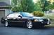2002 Ford Crown Victoria - A black 2002 Ford Crown Victoria LX Sport is parked in a suburban driveway next to a garage.