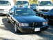 2002 Ford Crown Victoria - A black 2002 Ford Crown Victoria police car is parked outdoors, a light bar on the roof and a visible license plate.