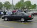 2002 Ford Crown Victoria - A black 2002 Ford Crown Victoria sedan is parked in a lot with other vehicles and people.