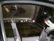 2002 Ford Crown Victoria - The interior of a vehicle shows damage to the headliner and exposed metal framing, with some papers attached to the pillar.
