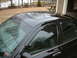 2002 Ford Crown Victoria - The roofline of a black 2002 Ford Crown Victoria is visible, a sunroof and window visors.