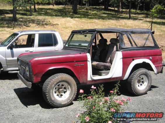 red 1968 Ford Bronco with white doors parked next to a silver SUV