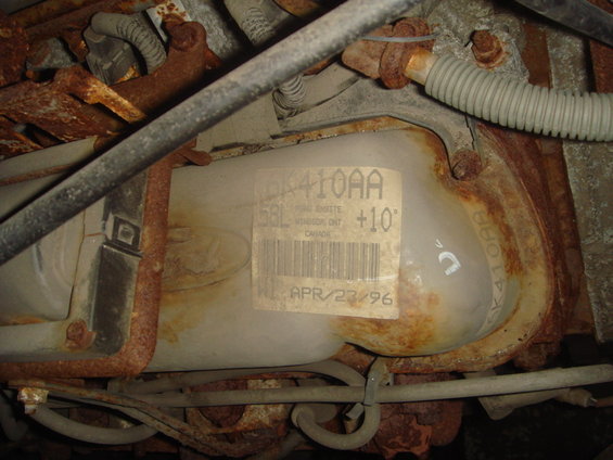 Close-up of a rusty engine part with a label showing 'APR/23/96'