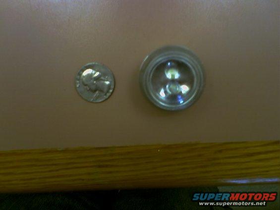 Dime next to a small round light fixture