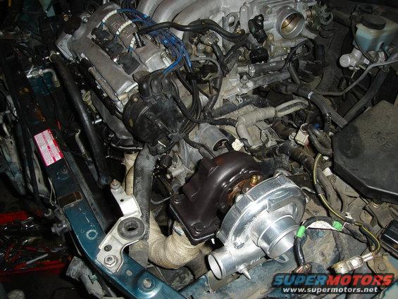 Engine bay showing a turbocharger and exhaust manifold with heat wrap
