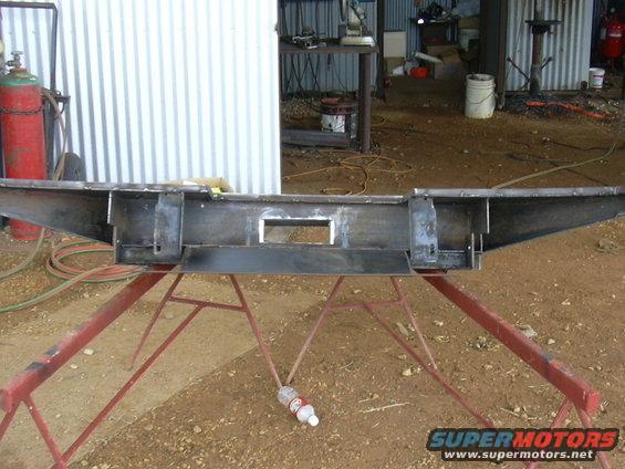 Custom fabricated steel bumper on red sawhorses in a workshop