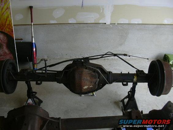 Rear axle assembly on jack stands, with brake drums and lines visible