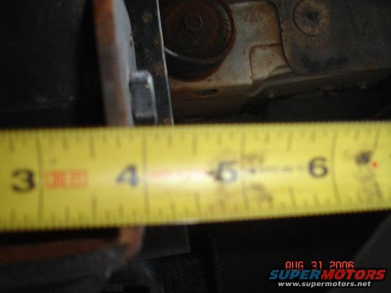 Tape measure showing about 5 inches of clearance under a vehicle frame