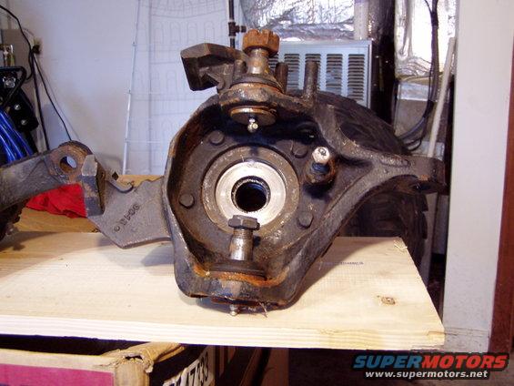 close-up of a rusty truck spindle and knuckle assembly with ball joints