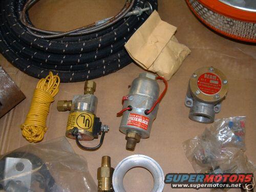 Various vehicle parts including a coiled yellow wire, a black hose, a filterlock, and a red-labeled component